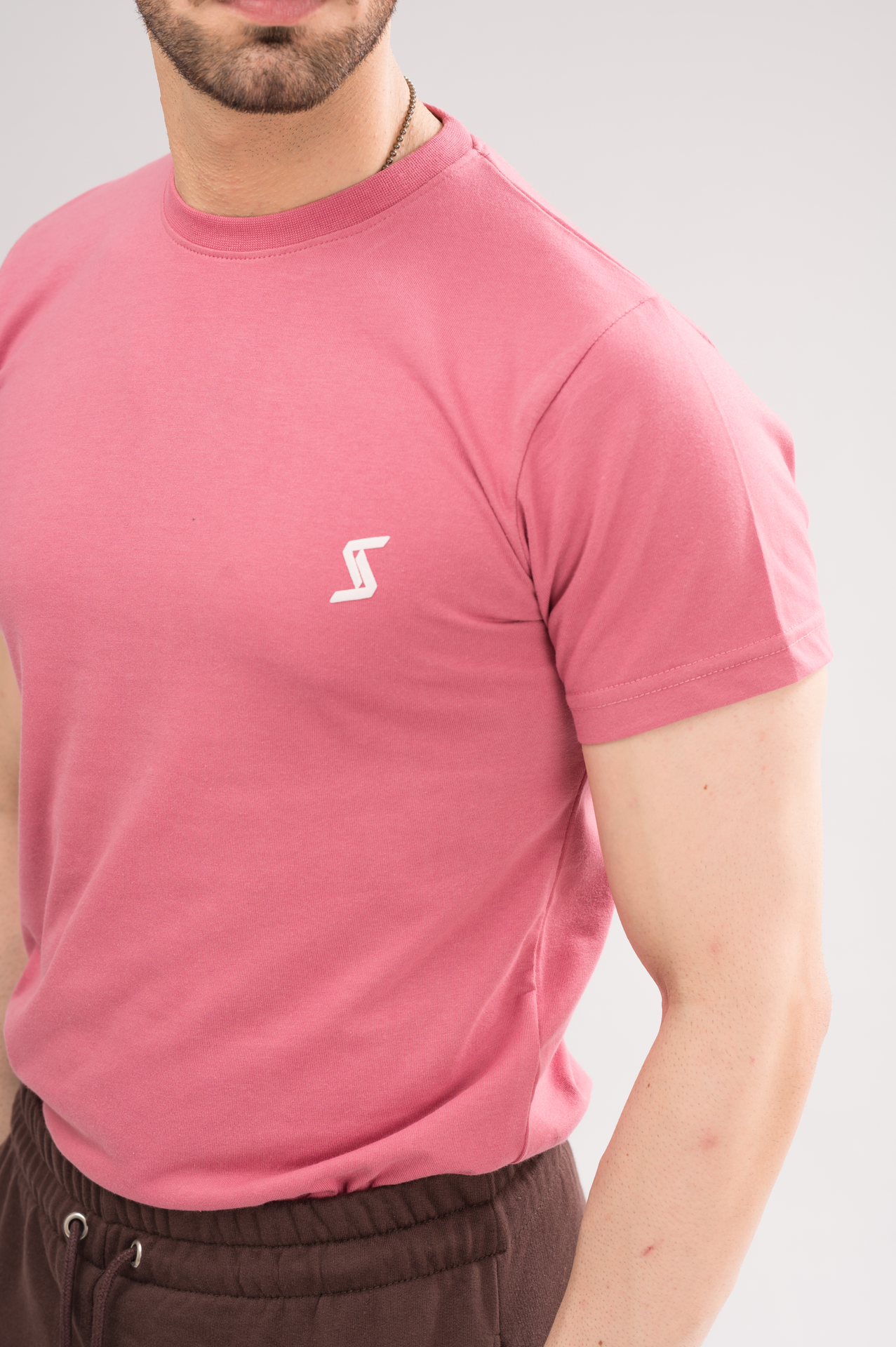 Close-up of Rapture Rose Regular Fit T-Shirt material, highlighting soft fabric and printed logo detail.