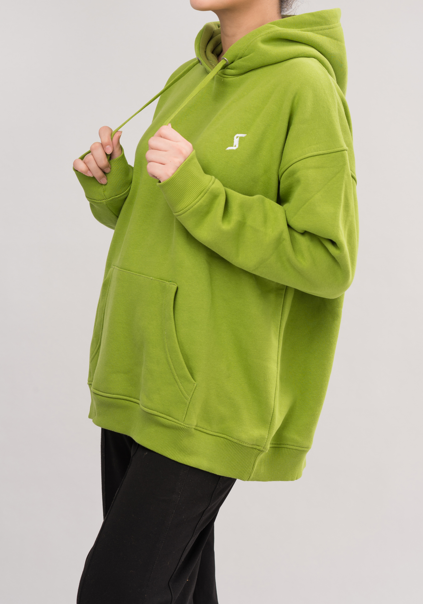 Side view of Women’s Classic Oversized Hoodie in Greenoble Green. Experience luxury with a soft brushed interior and a convenient kangaroo pocket.