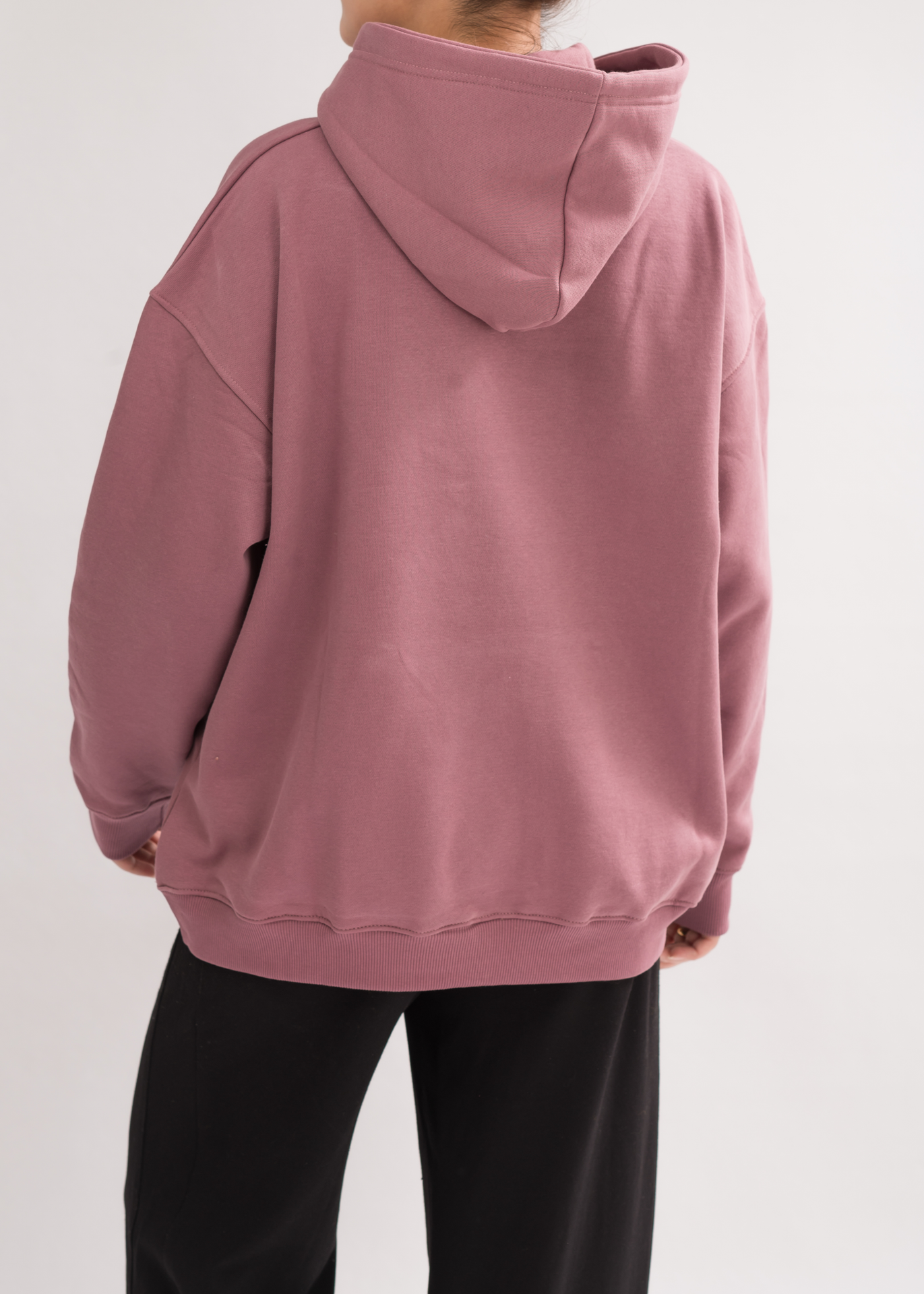 Back view of Women’s Classic Oversized Hoodie in Mauve Mist. Designed with a double-layered hood and dropped shoulders for a chic look.