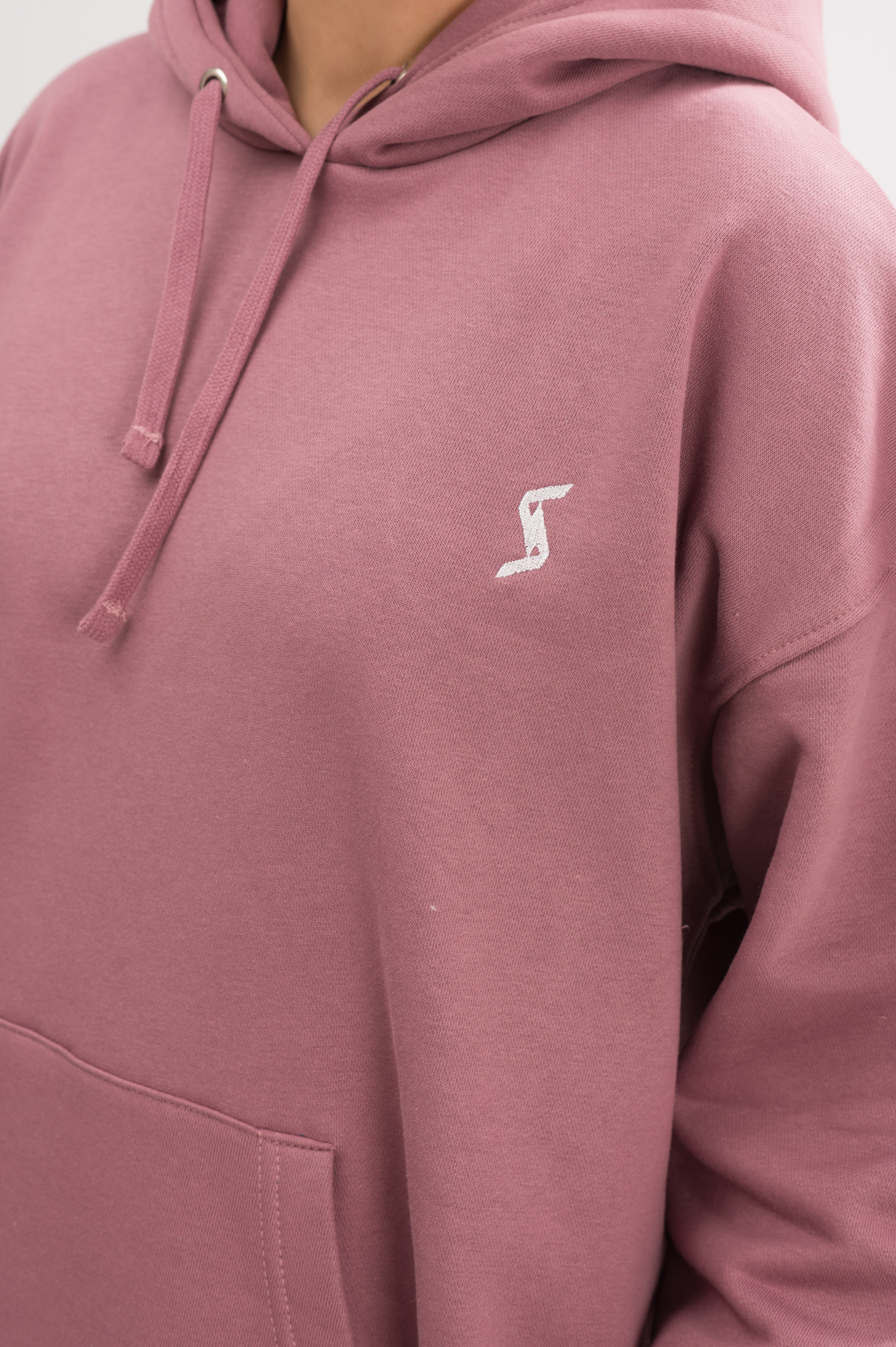 Side view of Women’s Classic Oversized Hoodie in Mauve Mist. Experience luxury with a soft brushed interior and a convenient kangaroo pocket.