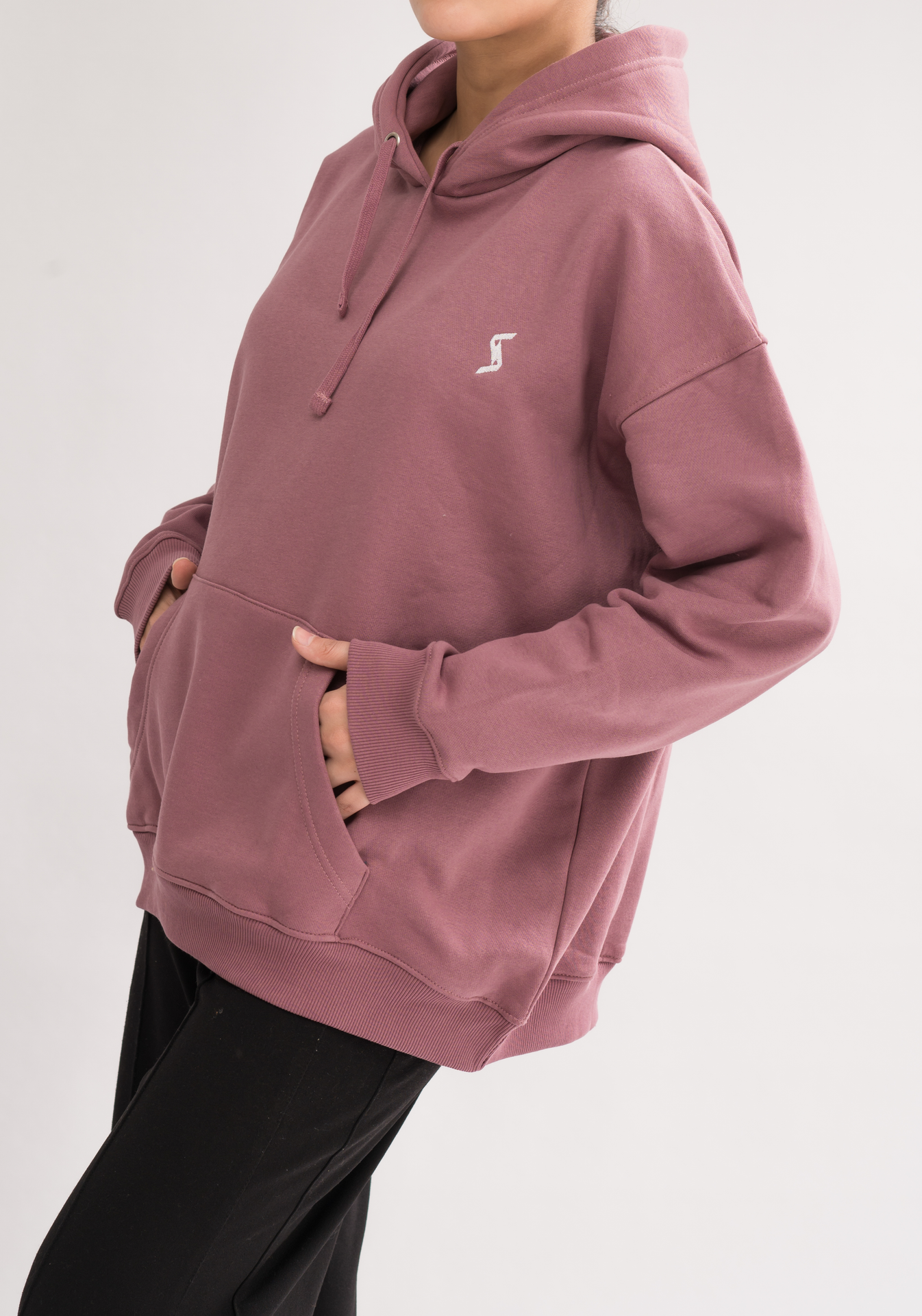 Side view of Women’s Classic Oversized Hoodie in Mauve Mist. Experience luxury with a soft brushed interior and a convenient kangaroo pocket.